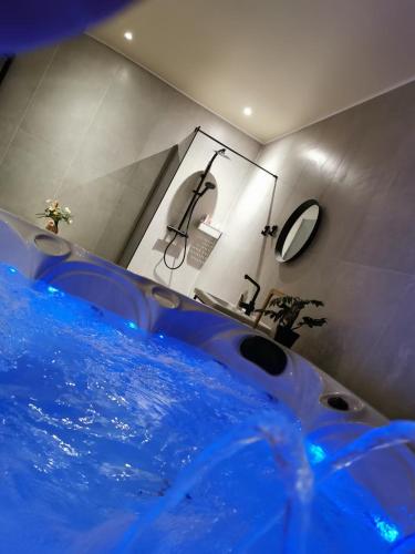 y baño con bañera azul y lavamanos. en Mica beauty & wellness center, en Temse