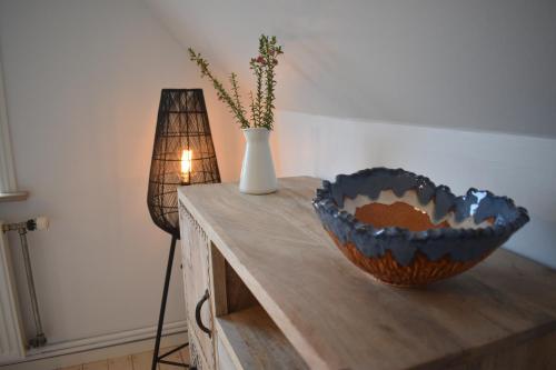 a table with a bowl and a vase on it at Viking Surf House in Klitmøller