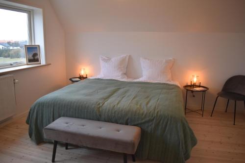 a bedroom with a large bed with a green bedspread at Viking Surf House in Klitmøller