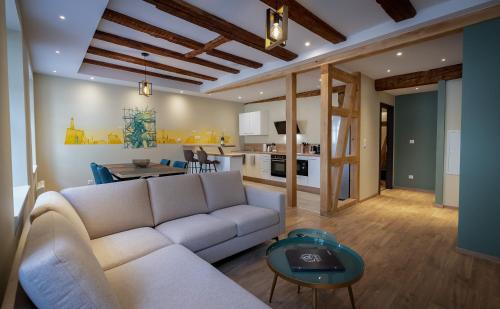 un salon avec un canapé blanc et une table dans l'établissement SERENITY Colmar - Gîtes de Prestige 4 et 5 étoiles - 2, 4 et 6 personnes- Centre Historique, à Colmar