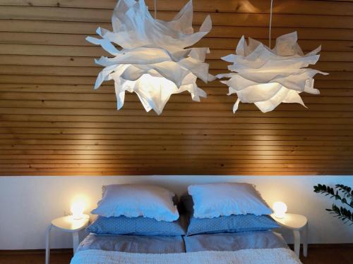 a bedroom with a bed with two lights and two lamps at Lakeview Guesthouse & Chalet Bled in Bled