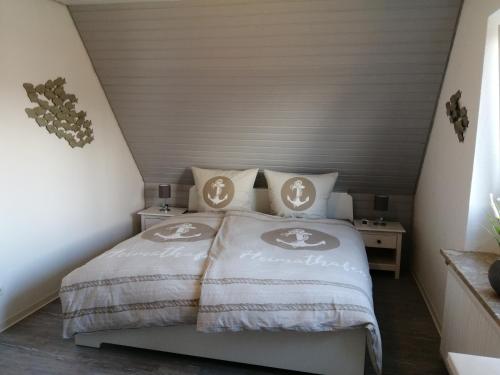 a bedroom with a bed with two pillows on it at Bude im Windrosenweg in Cuxhaven