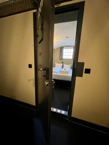 a door to a room with a bed and a mirror at Hotel Oostereiland in Hoorn