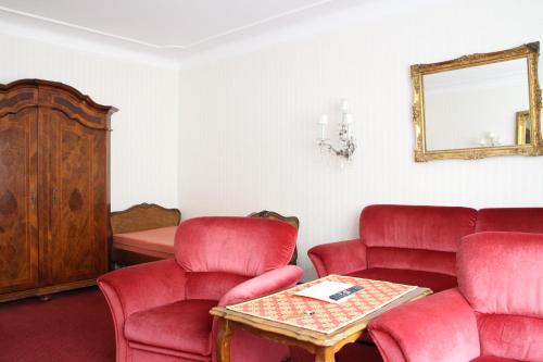 a waiting room with red chairs and a mirror at Pension Suzanne in Vienna