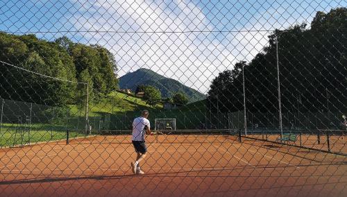 a man playing tennis on a tennis court at Feel like Home - vista montagna, vicino lago di Como in Maggio