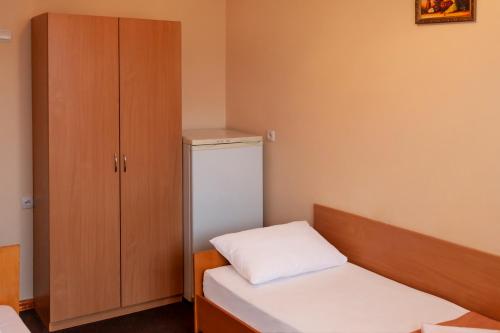 a small room with a bed and a cabinet at Tourist Chernivtsi in Chernivtsi