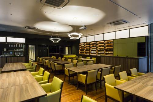 a restaurant with wooden tables and yellow chairs at Hotel Ryumeikan Ochanomizu Honten in Tokyo