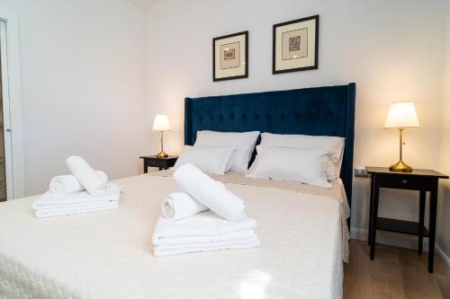 a bedroom with a large white bed with towels on it at Art Apartment in Zadar