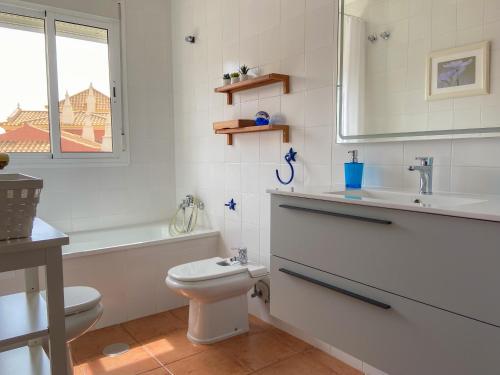 uma casa de banho com um WC, um lavatório e uma banheira em Disfrute de las playas y el golf en nuestro adosado en Islantilla - Costa de la Luz em Lepe