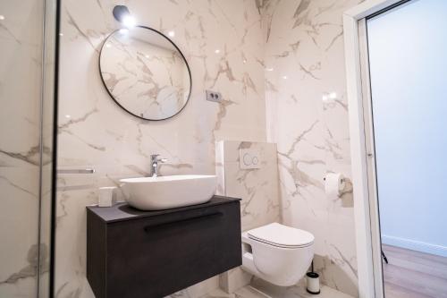 a bathroom with a sink and a toilet and a mirror at Art Apartment in Zadar