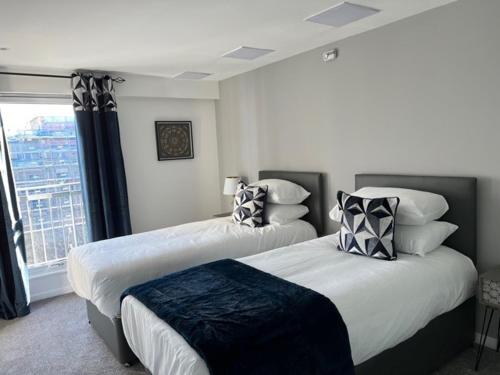 2 Betten in einem Zimmer mit Fenster in der Unterkunft Modern & Spacious 2 bed Merchant City Apart-High St in Glasgow