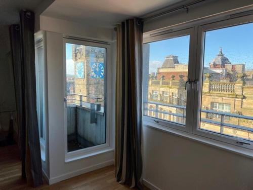 a room with a window with a view of a city at Modern & Spacious 2 bed Merchant City Apart-High St in Glasgow
