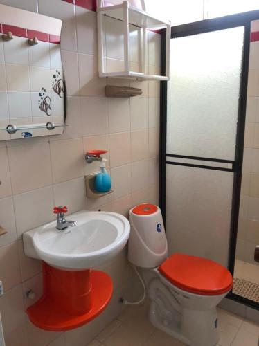 a small bathroom with a sink and a toilet at Hotel Los Corales Tulua in Tuluá