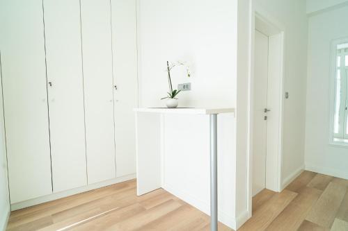 a white room with white cabinets and a table at Art Apartment in Zadar