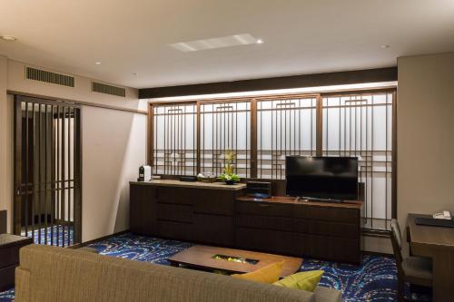 a living room with a couch and a flat screen tv at Hotel Ryumeikan Ochanomizu Honten in Tokyo