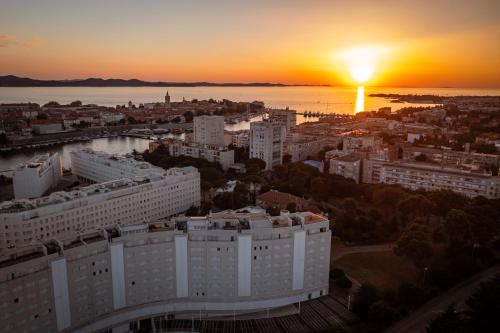 a view of a city with the sunset in the background at Art Apartment in Zadar