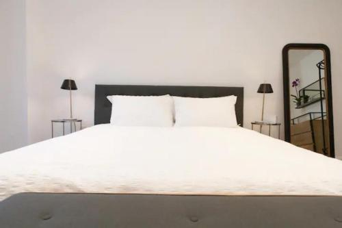 a bedroom with a large white bed with a mirror at Shoreditch - Immaculate 2 Bedrooms Flat for 6 in London