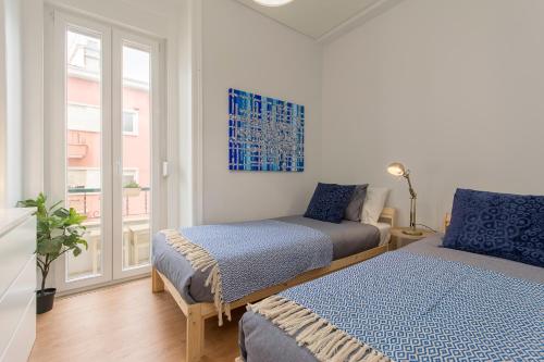 sypialnia z 2 łóżkami i oknem w obiekcie Charming Apartment for a Great Stay in Lisbon w Lizbonie