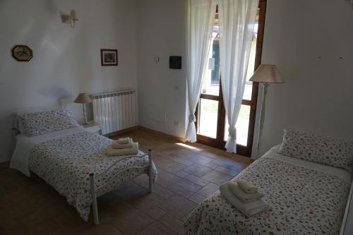 a bedroom with two beds and a large window at Oasi Del Verde in Soriano nel Cimino