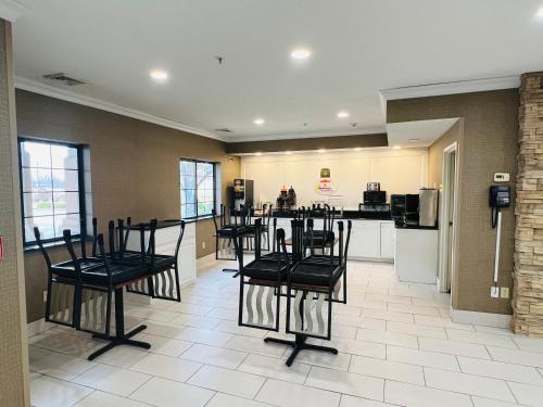 a kitchen with black chairs and a kitchen with a counter at Super 8 by Wyndham South Bend in South Bend