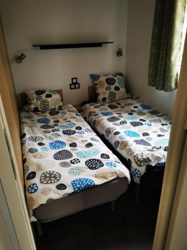 Cette petite chambre comprend 2 lits jumeaux. dans l'établissement Mobil home 8 personnes camping l ile d or saint raphael, à Saint-Raphaël