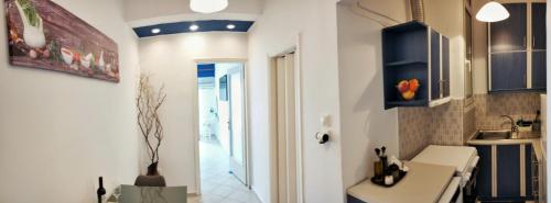 una cocina con armarios azules y fregadero en CozyCoast en Rafína
