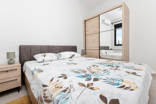 a bedroom with a bed and a large mirror at Ell Star Apartment in Tivat