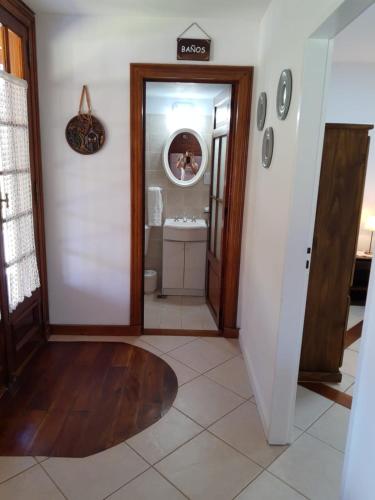 a hallway with a bathroom with a toilet and a mirror at Complejo Tierra Mia in Panaholma