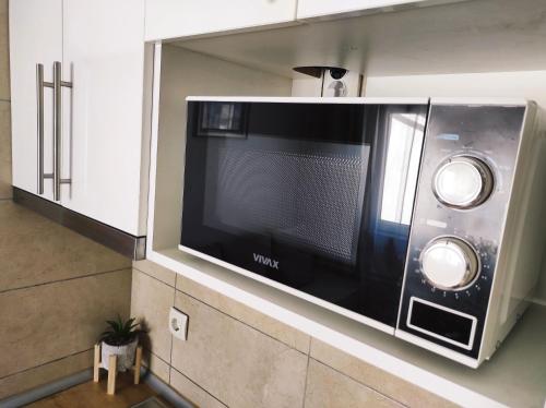 a microwave hanging on a wall in a kitchen at Apartment Katica Mostar in Mostar