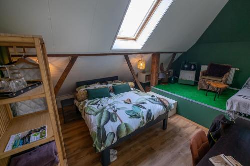 een slaapkamer op zolder met een bed en een ladder bij Rumah Indo Garden in Wilp