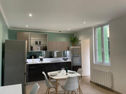 - une cuisine avec une table et des chaises dans la chambre dans l'établissement la casa verde 2 chambres 2 salles de bain 2 wc jardin, à Compiègne