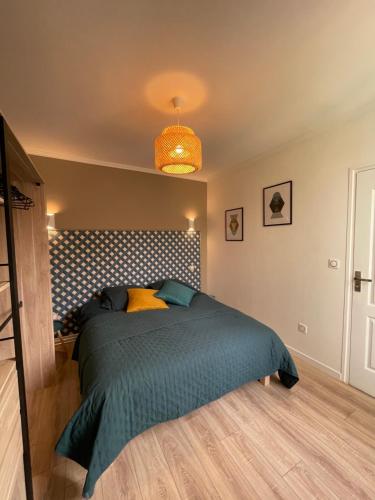 - une chambre avec un lit et une couette bleue dans l'établissement la casa verde 2 chambres 2 salles de bain 2 wc jardin, à Compiègne