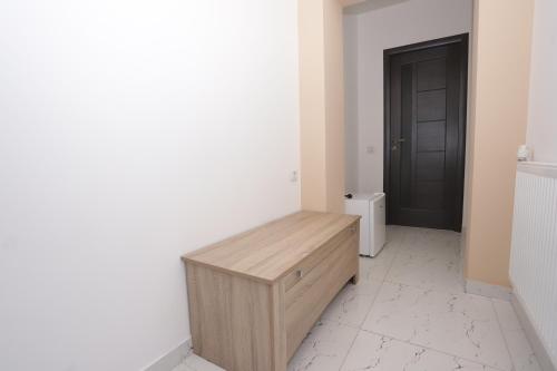 a room with a wooden bench in front of a door at CENTRAL VIEW Craiova in Craiova