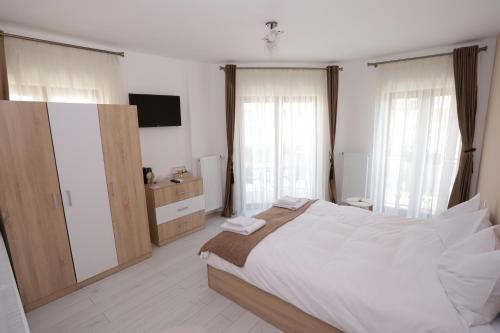 a bedroom with a large bed and a television at CENTRAL VIEW Craiova in Craiova