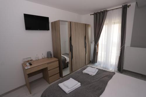 a room with a bedroom with a desk and a television at CENTRAL VIEW Craiova in Craiova