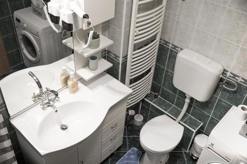 a bathroom with a white sink and a toilet at Apartman Tara in Varaždin