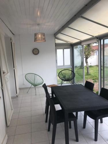 une salle à manger avec une table et des chaises noires dans l'établissement Maison port de la guittière, à Talmont-Saint-Hilaire