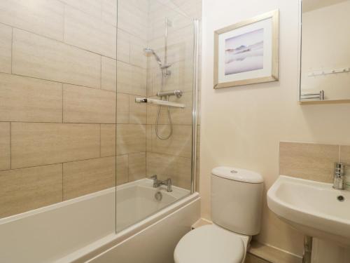 a bathroom with a shower and a toilet and a sink at Burford Cottage in Weston on Avon