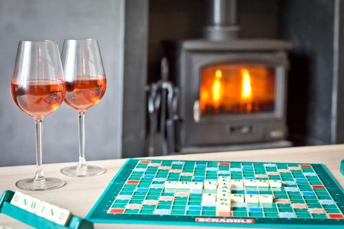two glasses of wine on a chess board with a fireplace at Harley House in Broughton in Furness