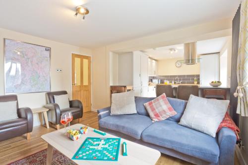 a living room with a blue couch and a table at Harley House in Broughton in Furness