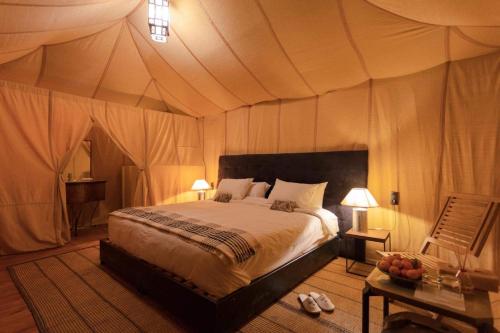 a bedroom with a bed in a tent at Camp Sahara berber in Merzouga