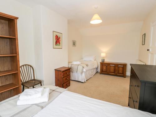 a bedroom with a bed and a dresser and a desk at Groes Newydd in Llandecwyn