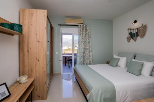 ein Schlafzimmer mit einem Bett und einem Tisch und einem Fenster in der Unterkunft Studio Athena with panoramic view of MakryGialos in Pilalímata