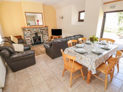 a living room with a table and chairs and a couch at Hill Top Farm Cottage in Minwear