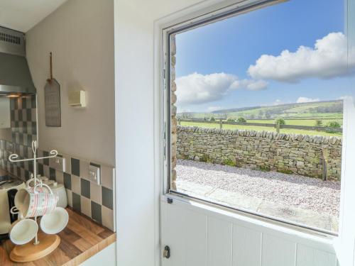 eine Tür mit einem Fenster mit Blick auf eine Steinmauer in der Unterkunft School House Cottage in Newtown