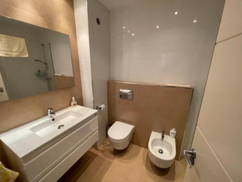 een badkamer met een wastafel, een toilet en een bad bij Precioso apartamento con piscina Urbanización Playazul in Cambrils