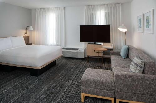 a hotel room with a bed and a couch at Sonesta Simply Suites Falls Church in Falls Church