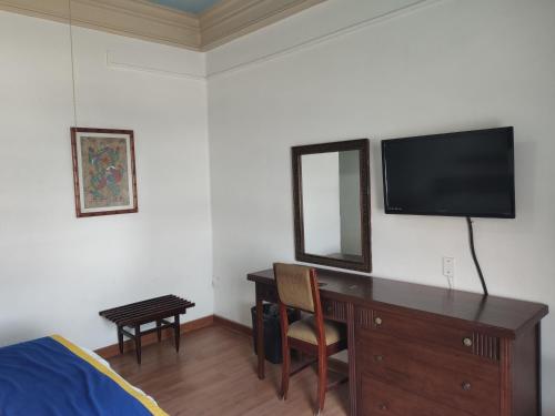 a bedroom with a desk with a television on a wall at Hotel Sierra Gorda in Ciudad Victoria