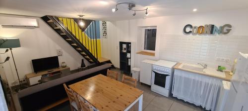 une cuisine avec une table et un évier, ainsi qu'un escalier. dans l'établissement Gite le Tilleul Vallon pont d'Arc, à Vallon-Pont-dʼArc