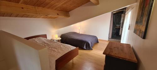 une chambre avec deux lits et une table dans une pièce dans l'établissement Gite le Tilleul Vallon pont d'Arc, à Vallon-Pont-dʼArc